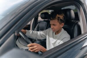 Jongeren in een auto tijdens rijles, met een rijinstructeur in Nederland.
